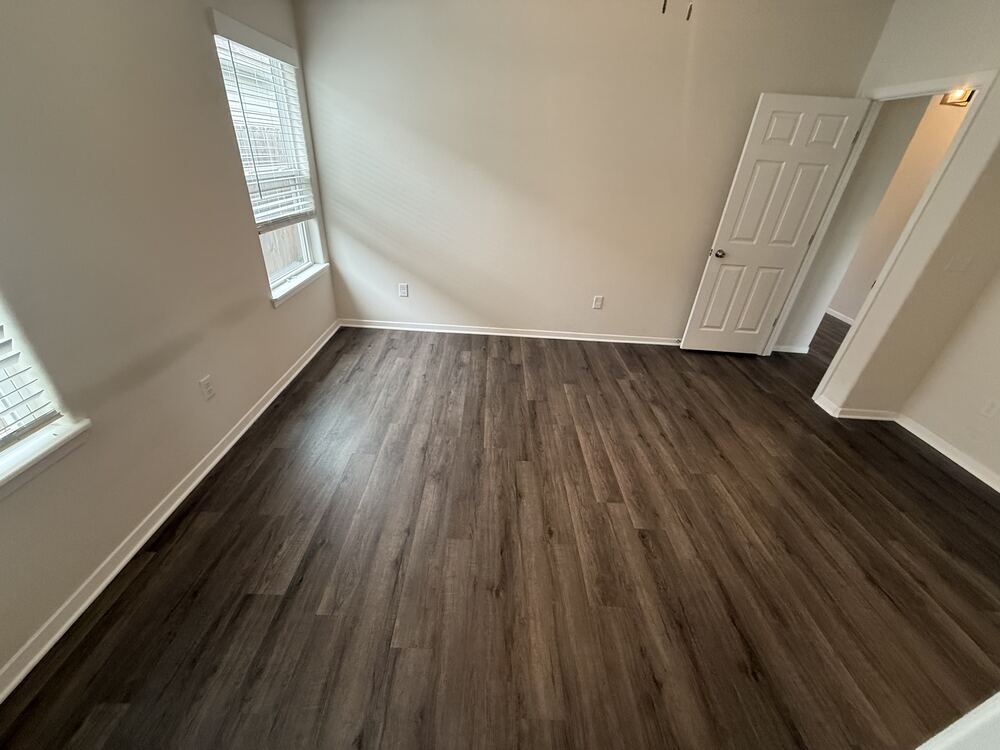 Dark wood-look vinyl plank flooring in an empty room